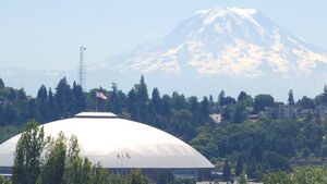 A close shot of Mt. Rainier, with the Tacoma Dome visible in the foreground.